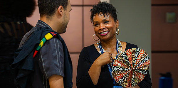Black female employee smiling at and interacting with student