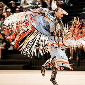 Female Indigenous dancer performing at a Pow Wow celebration