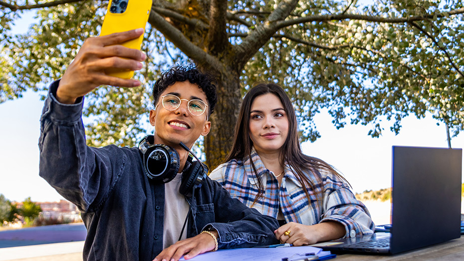 2 students taking a selfie at a picnic table