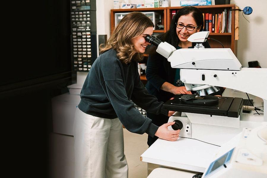 A woman looking through a microscope