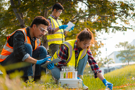 Three scientists outside taking a water sample with a text overlay "Innovation Stories"