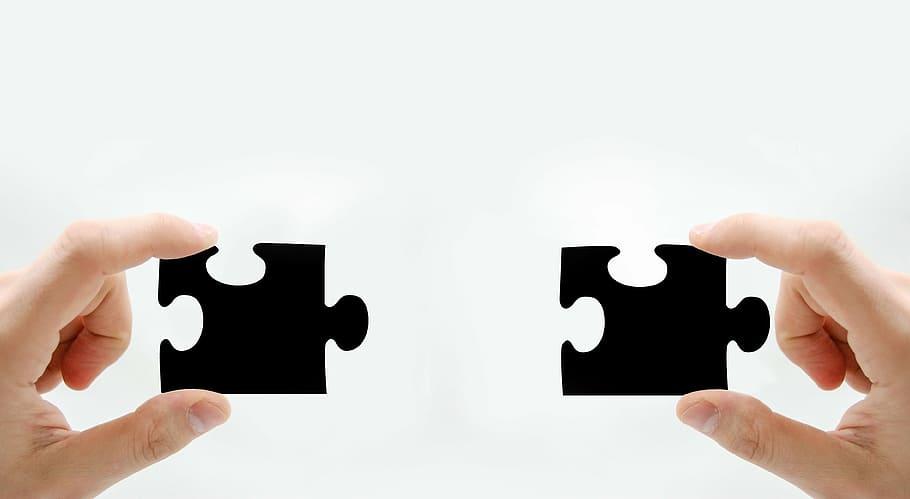 Two hands connecting puzzle pieces