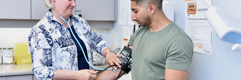 Student at clinic with doctor checking on him