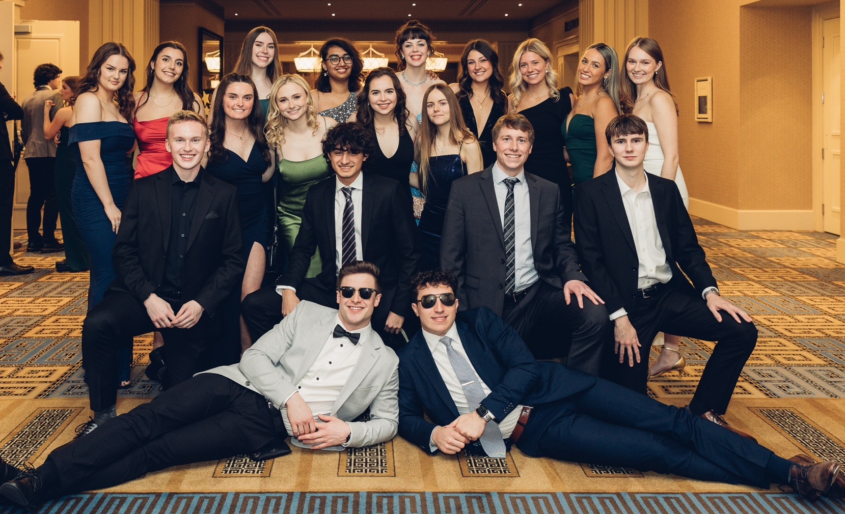 A group of students in formal attire in a hotel lobby