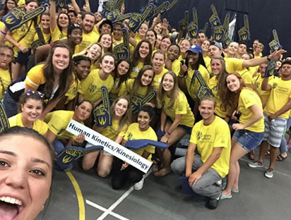 A group of 30+ students cheering at the camera