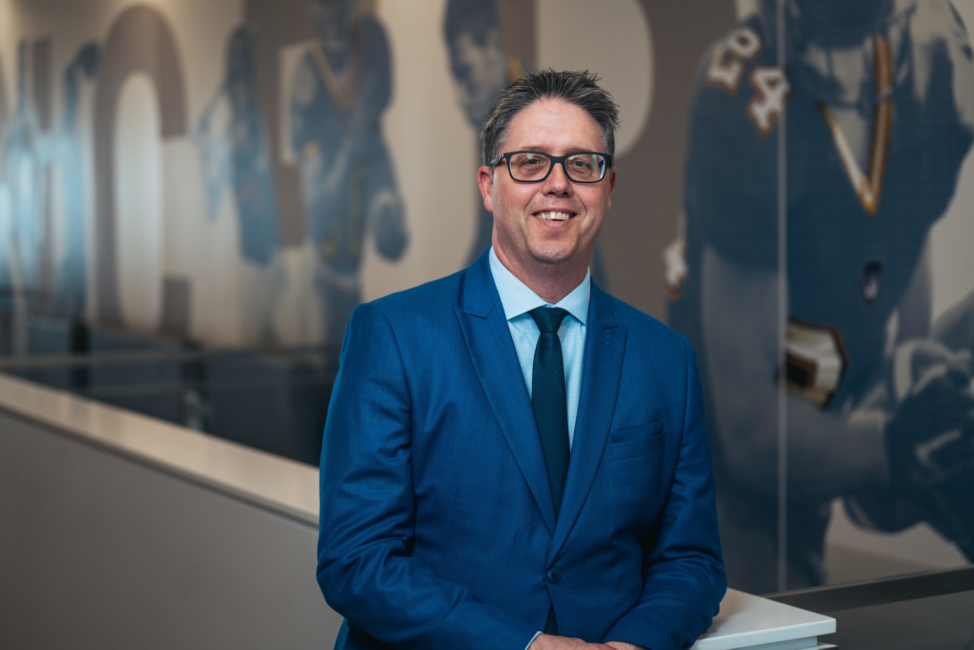 a man in a blue suit and glasses