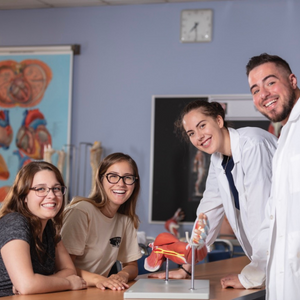 Four students in an anatomy lab smiling