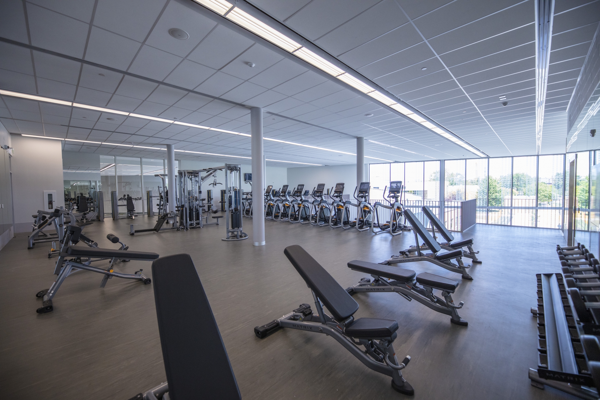 Wide shot of new fitness centre with various strength and cardio equipment 