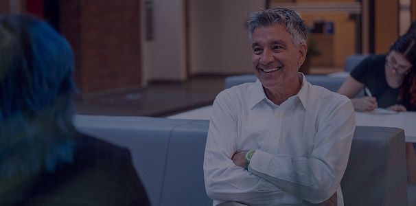 Professor in lounge smiling at camera