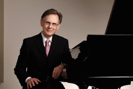 Pianist, Dr. Philip Adamson sitting at the Yamaha piano in the Heritage Auditorium