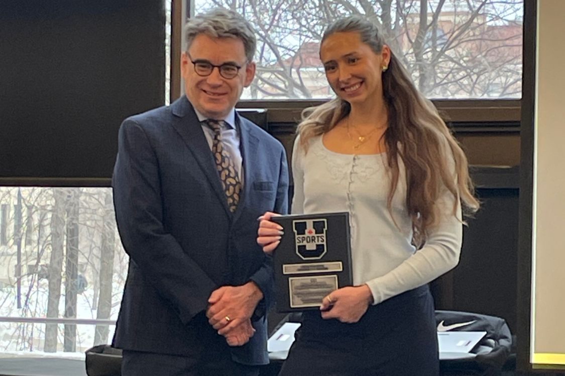 Chloe VidAmour receives the USPORTS service award plaque 