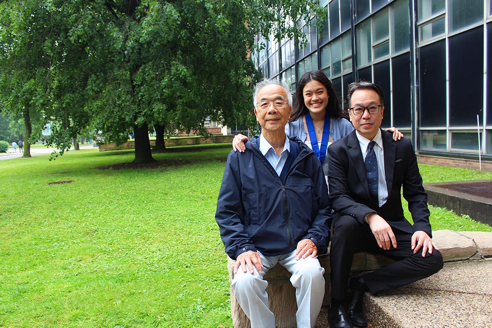 Gold LEAD Medallion Scholar Tiffany Huang smiling with her father, William Huang, and grandfather, Fore-lien Huang in front of Essex Hall 