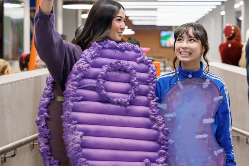Two students in purple microbe costumes take a selfie