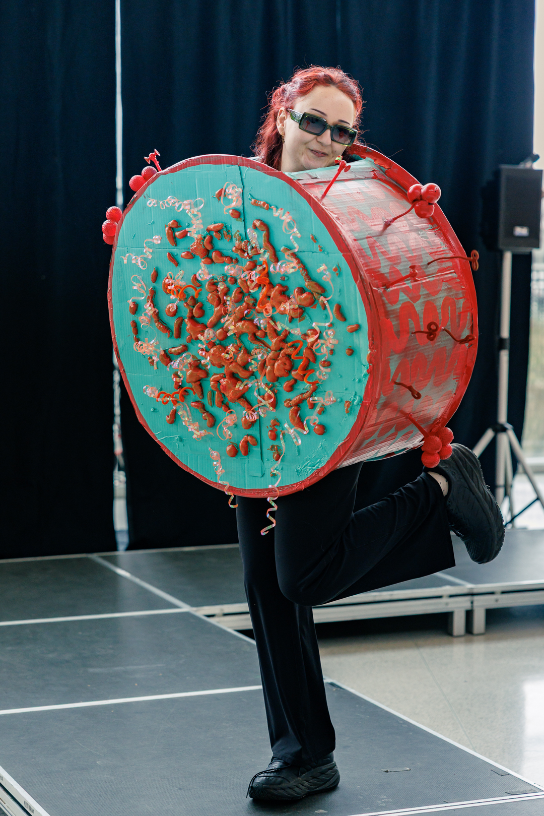 A student in a drum-like full body microbe costume