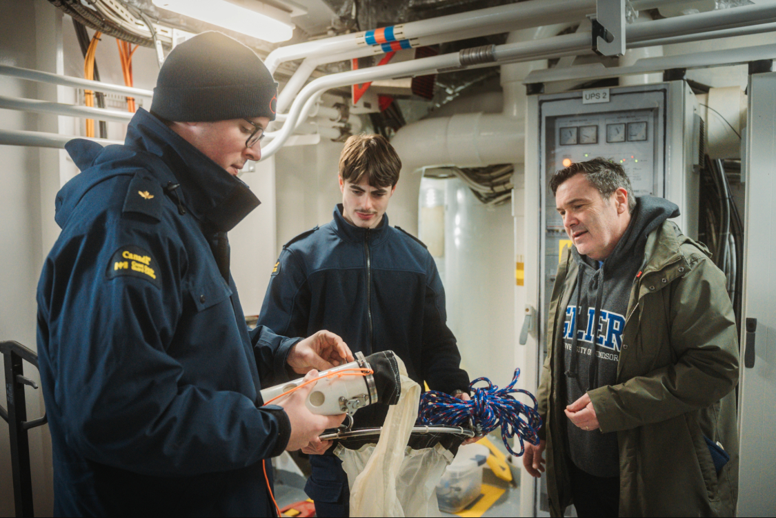 Dr. Mike McKay to the right talking to two Coast Guard cadets on the left