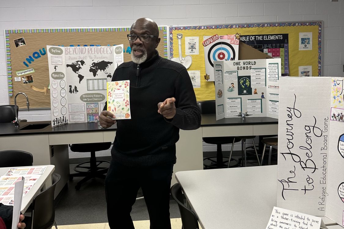 Dr. Clinton Beckford holding up a student cookbook