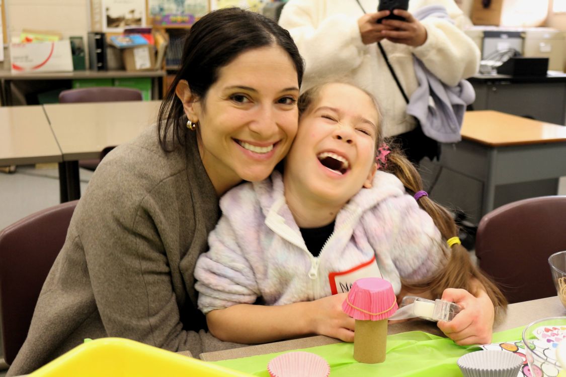 A woman hugs a smiling child