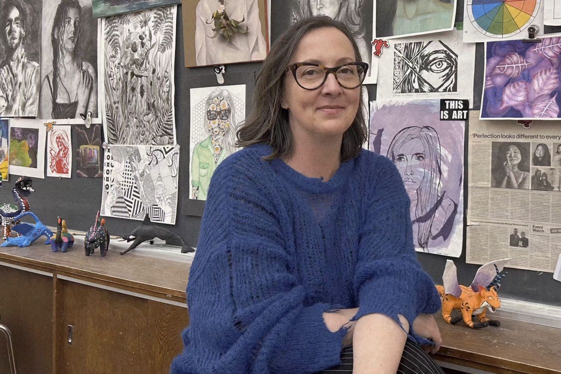 Sanja Srdanov in front of a wall of student art