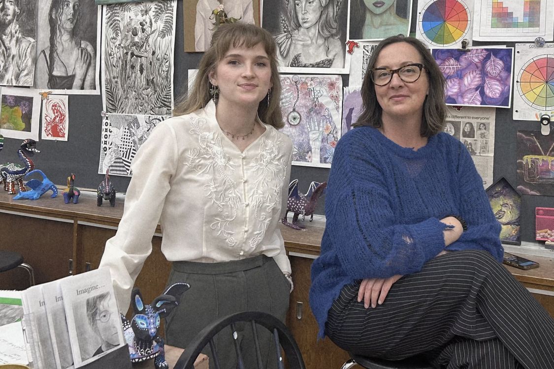 Sanja Srdanov and teacher candidate Morgan in front of a wall of student art