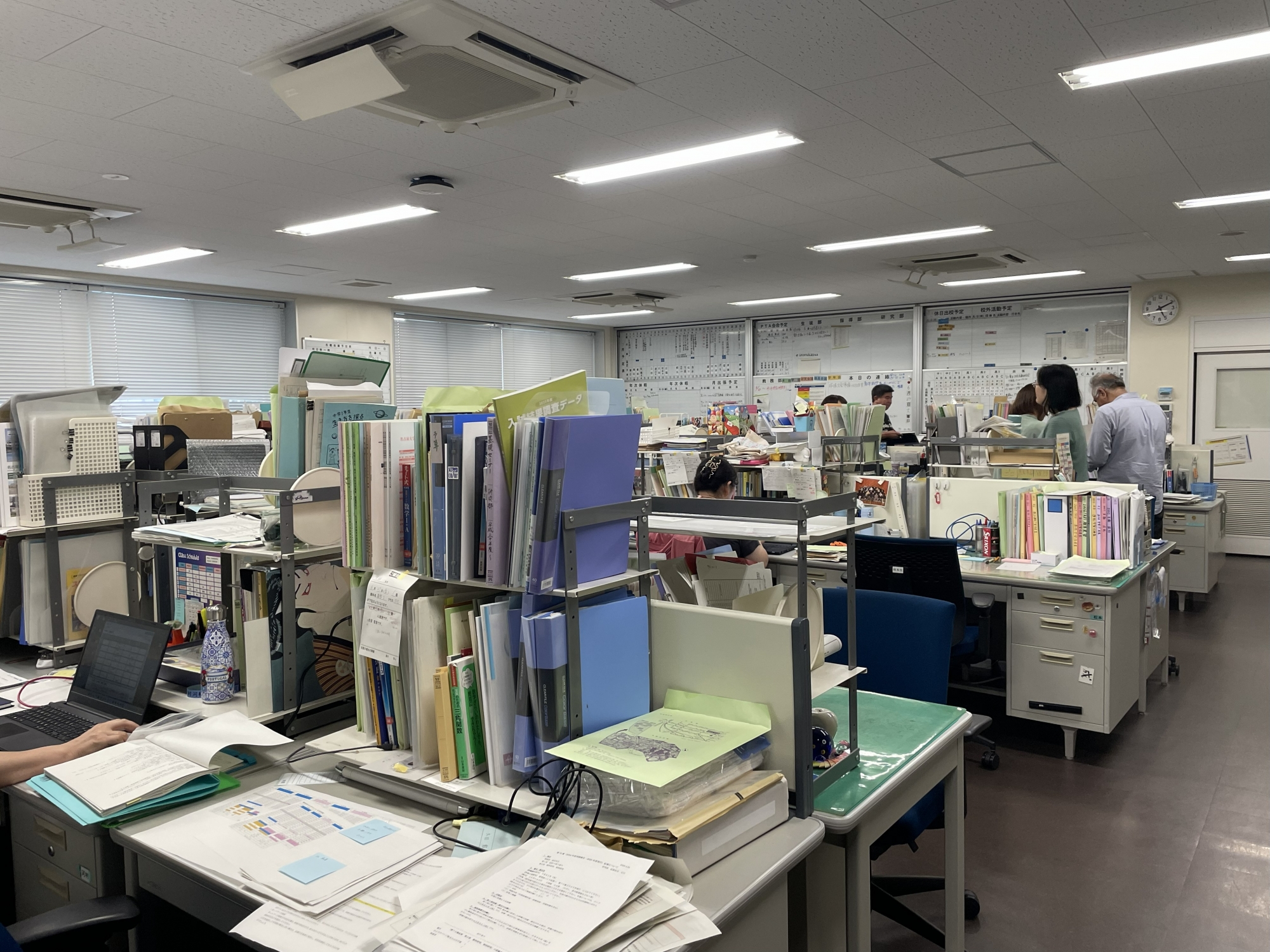 room full of desks and resource materials with teachers collaborating