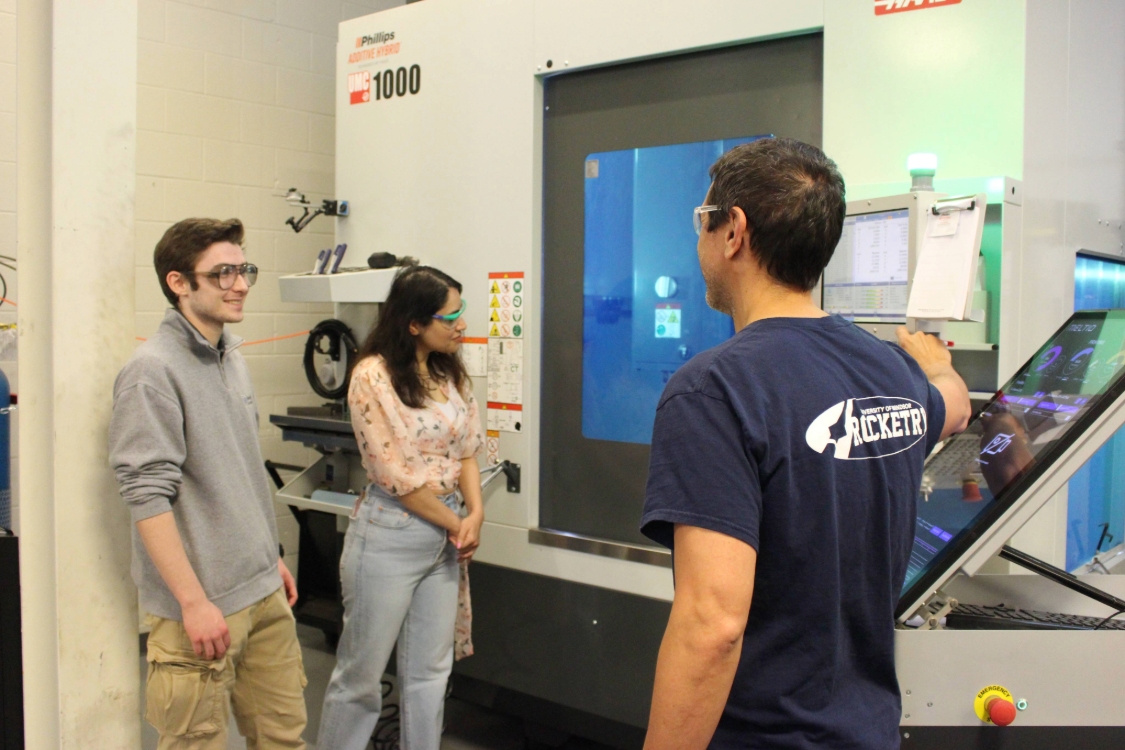 Technician shows students how to use the 3D printing machine at UWindsor