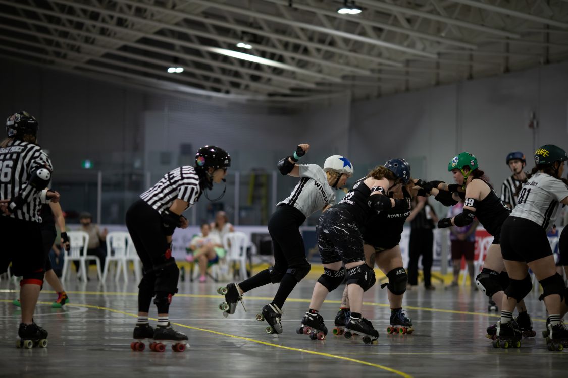 A jammer in a roller derby team sneaks past a wall of blockers