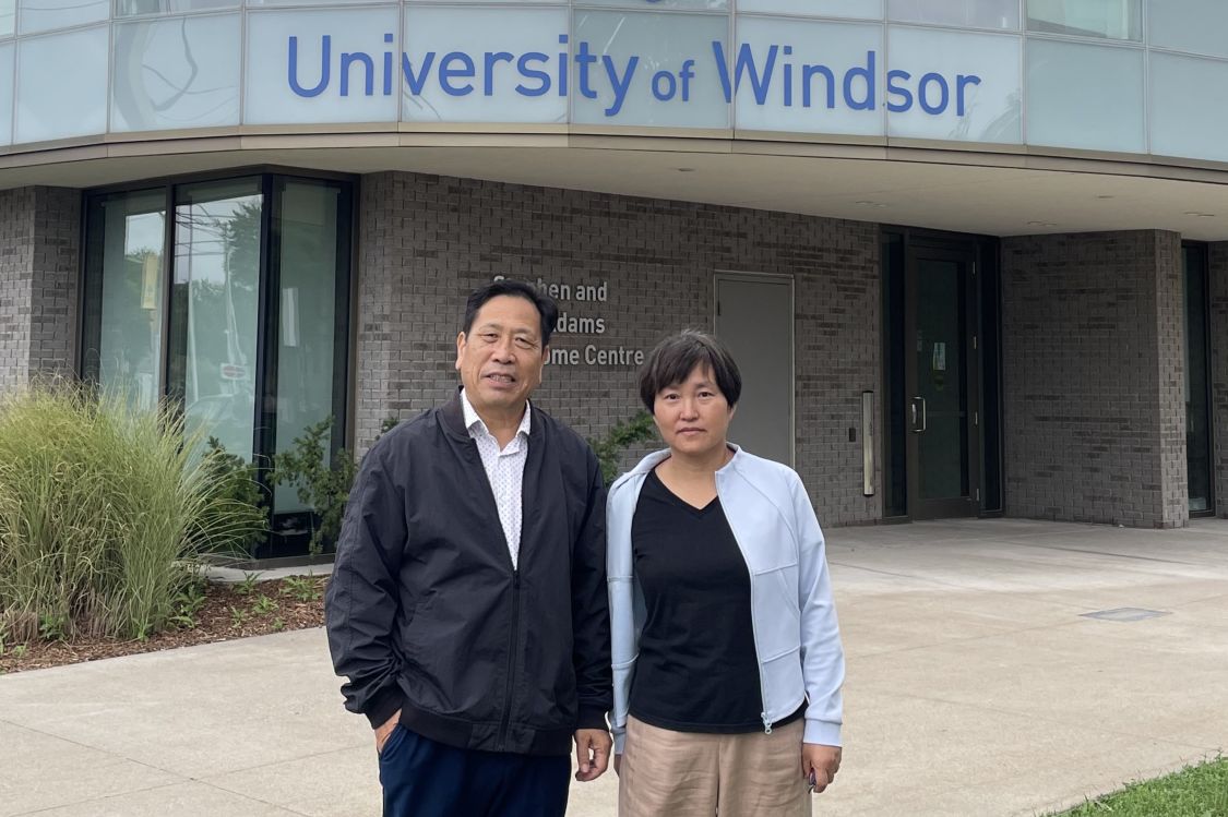 George Zhou and Guifang Cheng in front of the UWindsor Welcome Centre