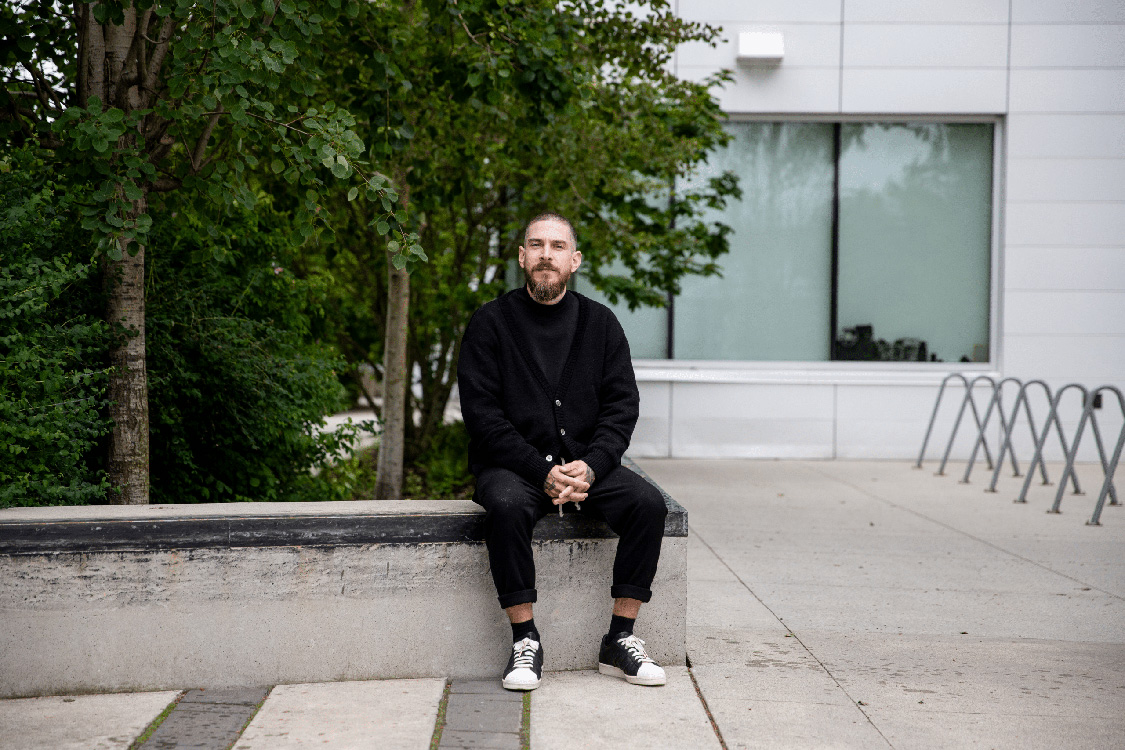 portrait of Justin Langlois seating in front of a building