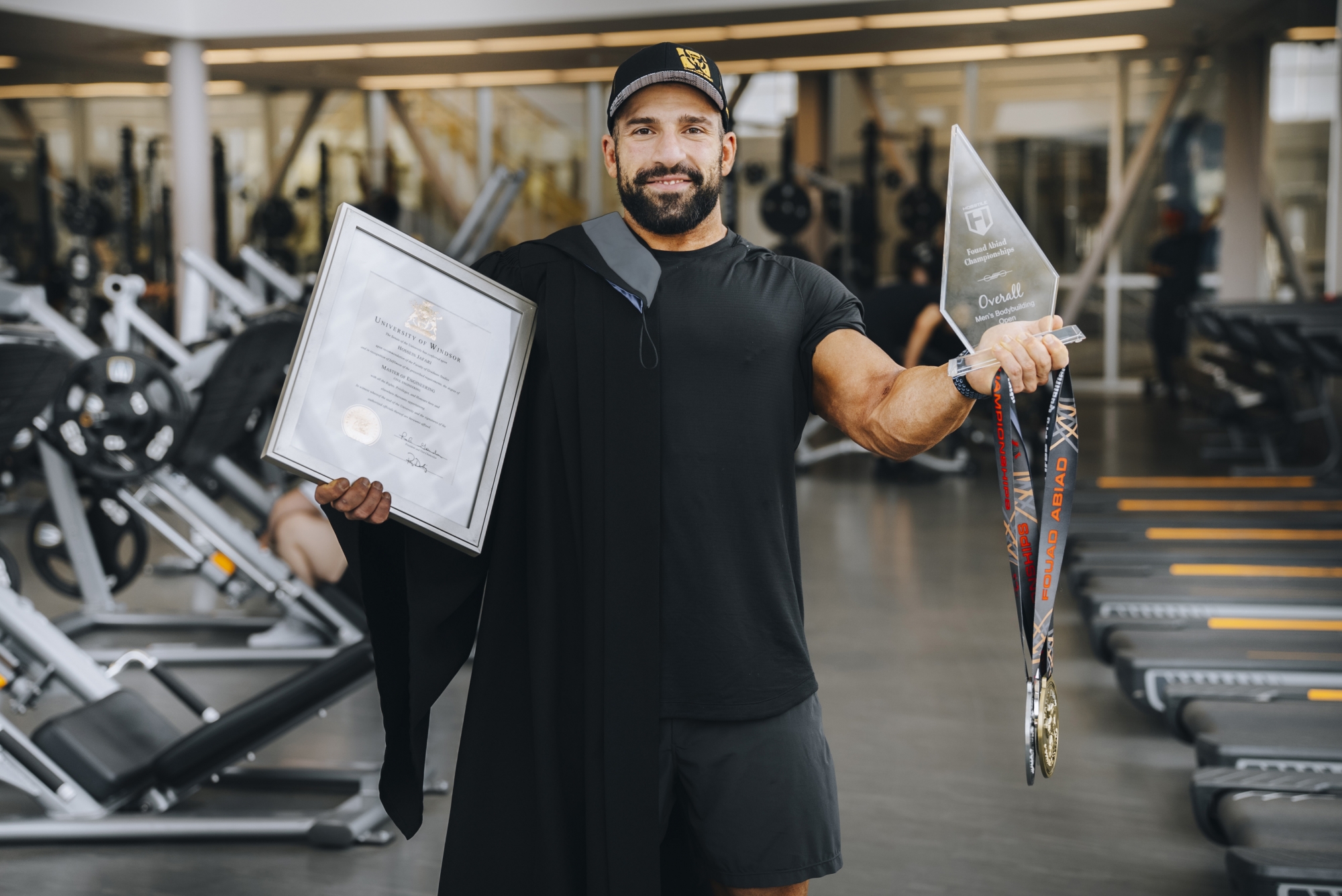 Hossein Jafari demonstrates his diploma and bodybuilding awards.