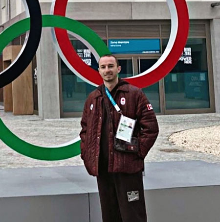 Anthony Pollock stands beside the Olympic rings statue in Milan.