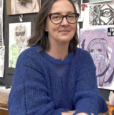 Sanja Srdanov in front of a wall of student art