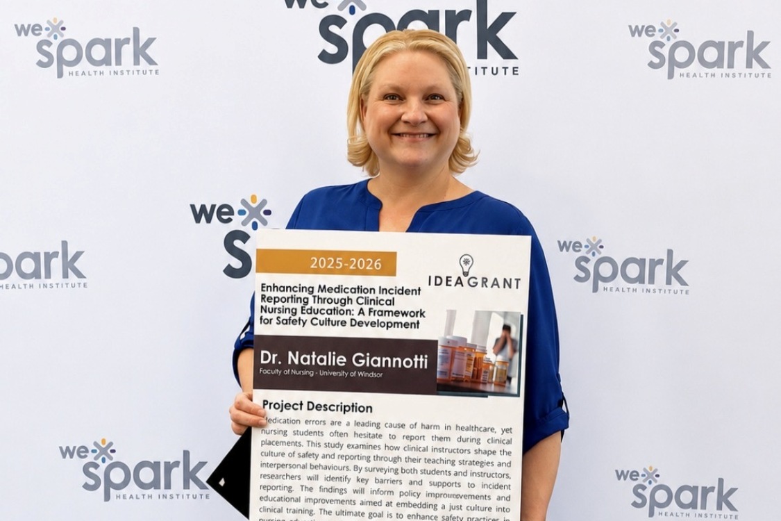 Natalie Giannotti holds a poster for her WeSpark grant project