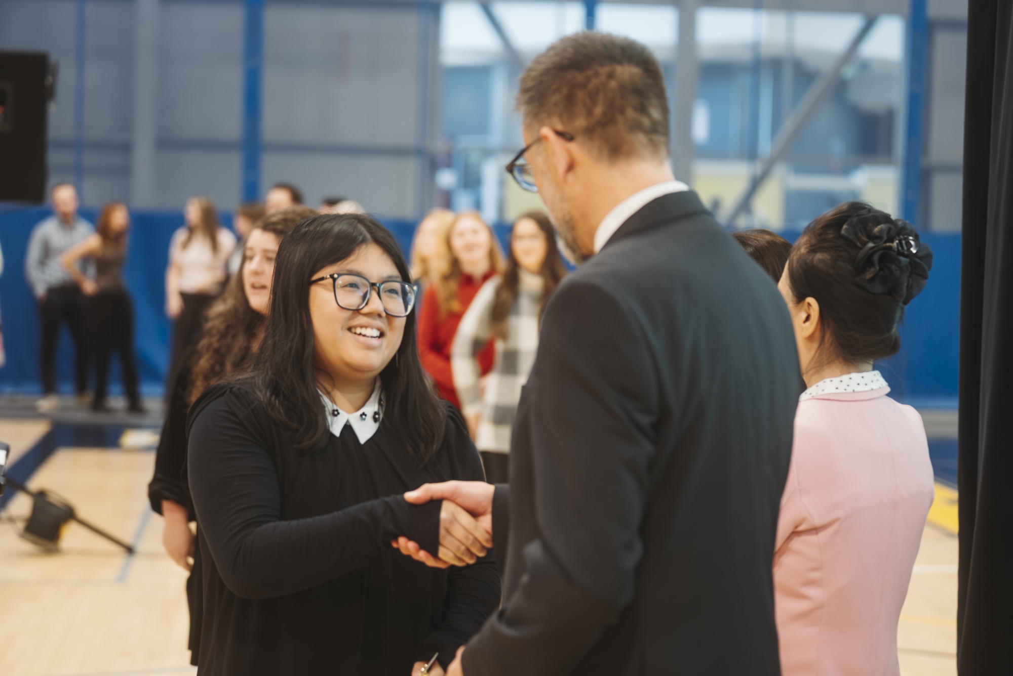 Ken Montgomery hands a student a pin