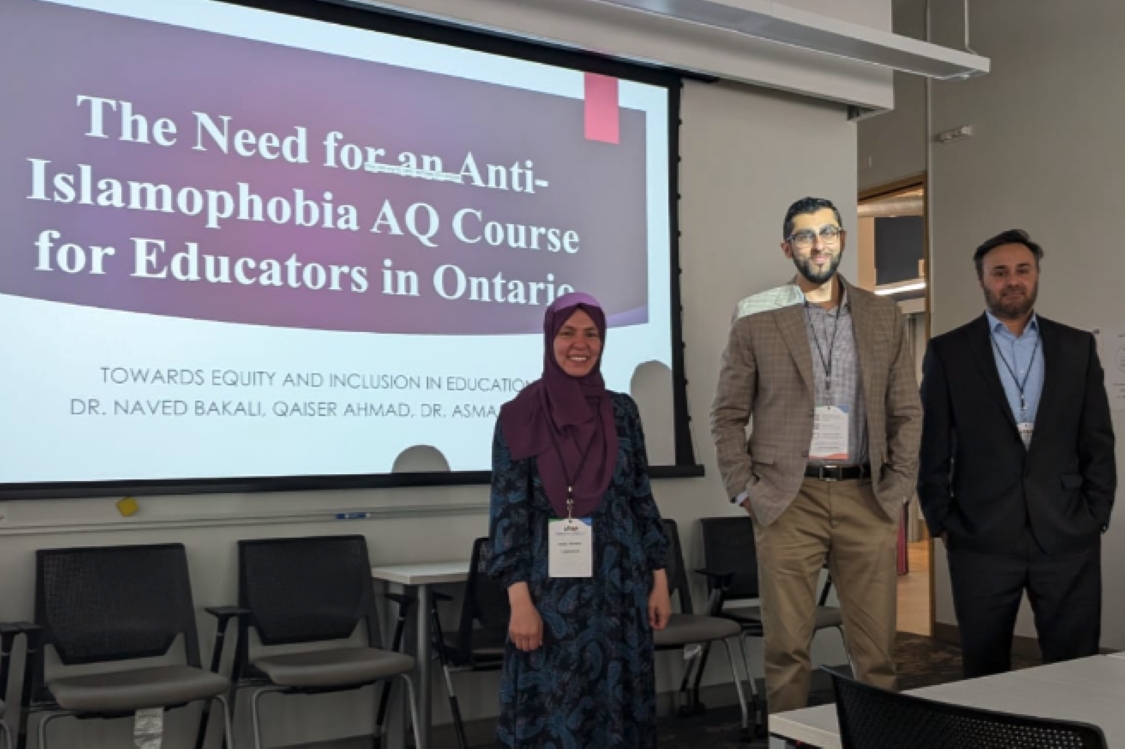 Asma Ahmed, Naved Bakali and Qaiser Ahmad in front of a projector screen with presentation slide about importance of AQ course