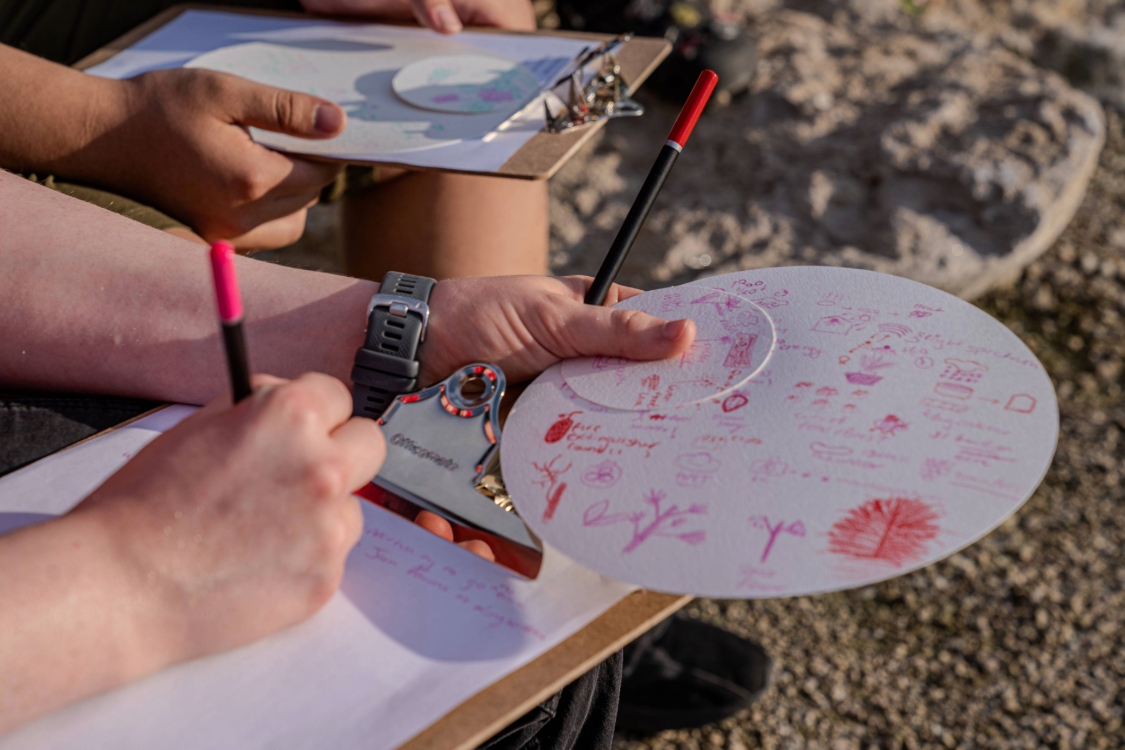 Students holding clip boards with sketches