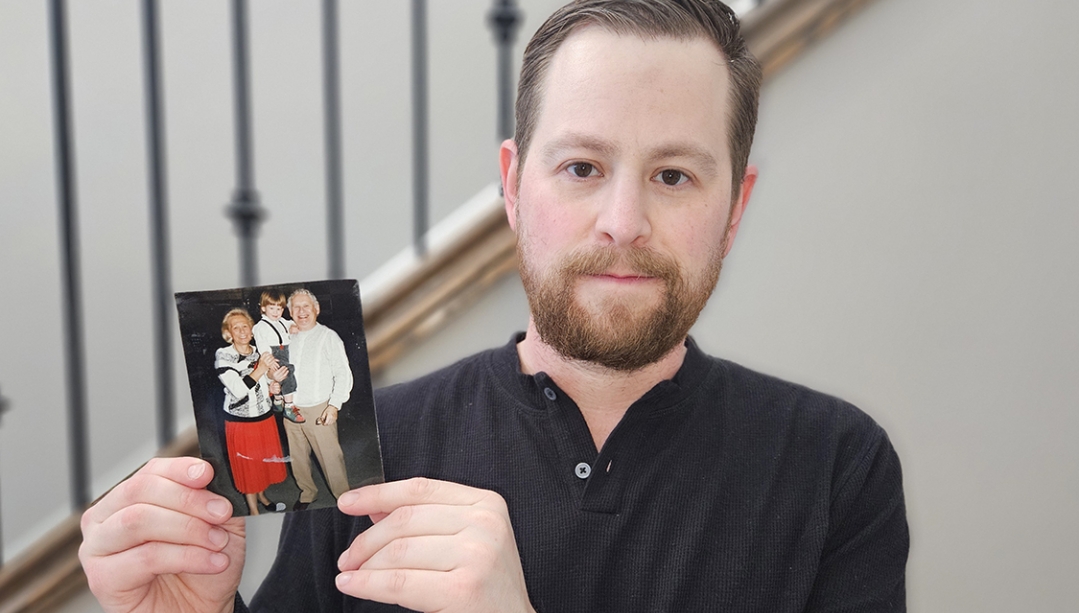 Dr. Kyle Brykman holds up a picture of his grandparents cradling him as a young boy