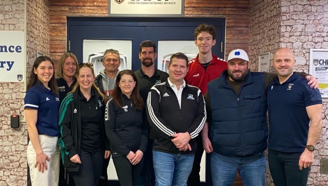 A group of people in front of the door for the Centre for Human Performance and Health