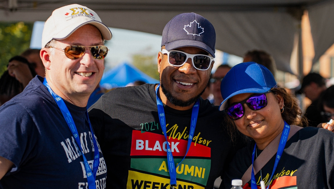Alumni pose for photo at Lancers football Alumni tailgate.