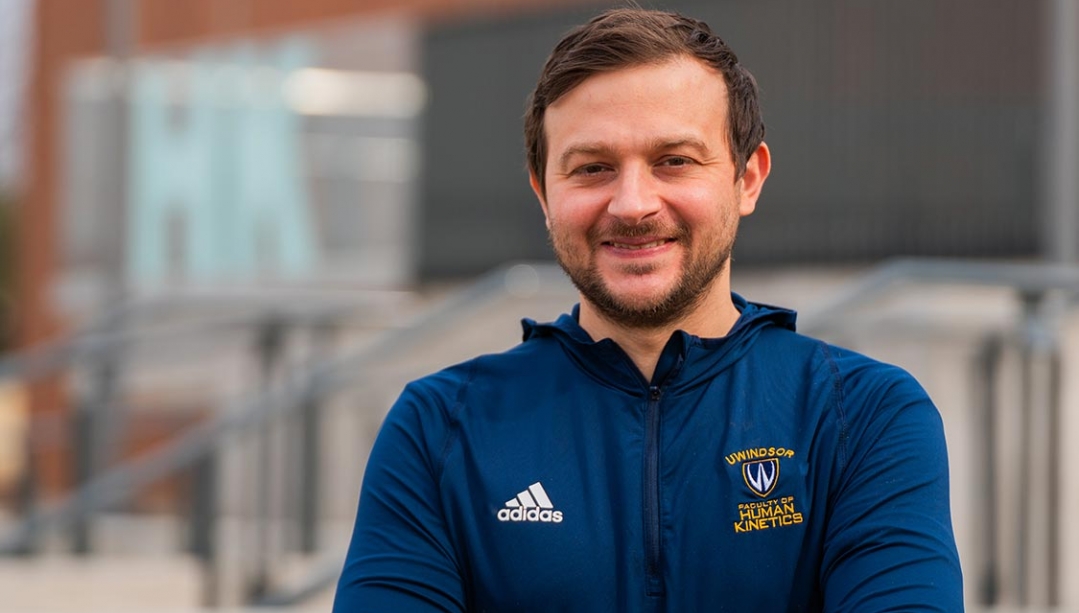 Francesco Biondi standing in front of UWindsor Human Kinetics building