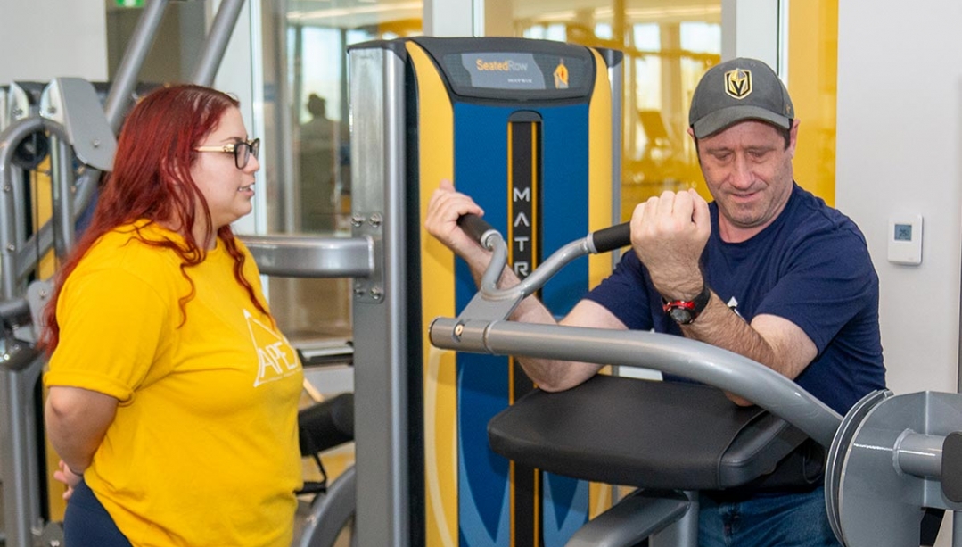 Mikala Jones leads Seth Sugarman through weight training