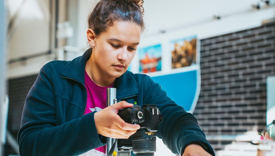 Olivia Galloway using camera to record sturgeon in tank