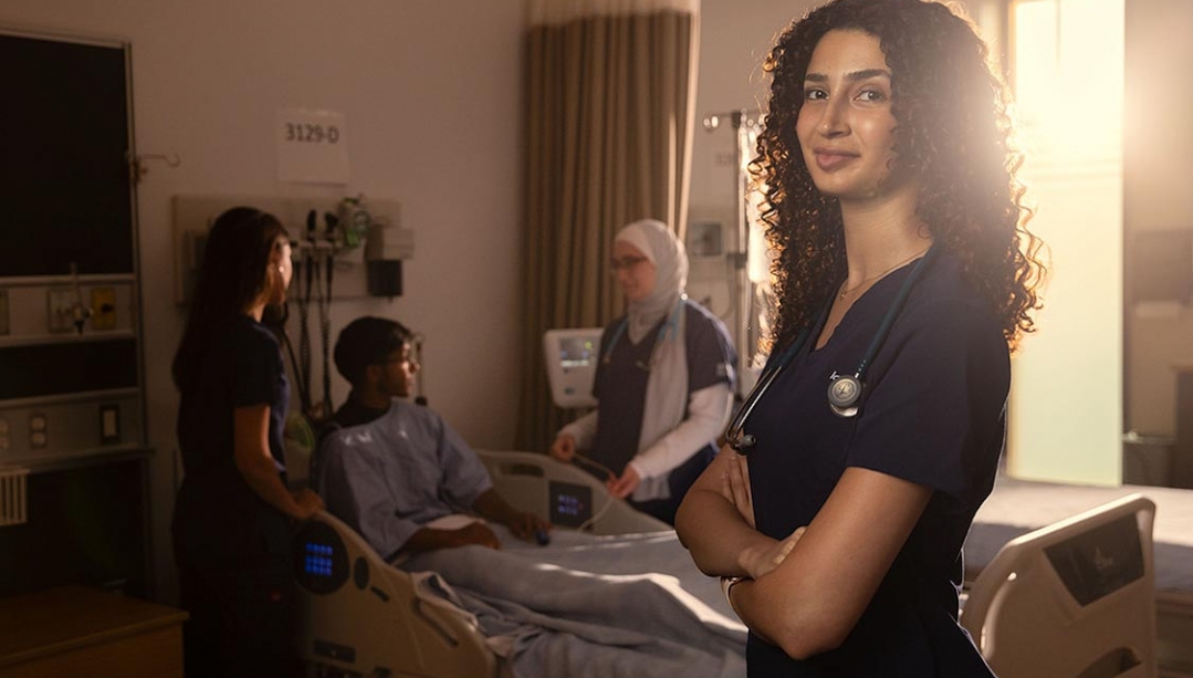 BScN student standing in general lab with other students in the background