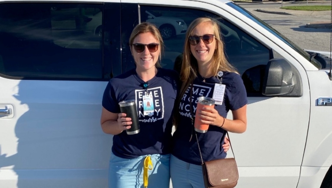 Destiny Cadarette stands beside a nursing colleague outside in front of a truck