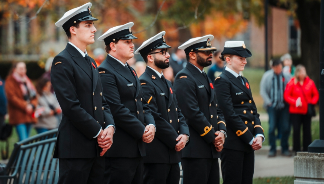 Royal Canadian Navy members and students observe a moment of remembrance during a campus service