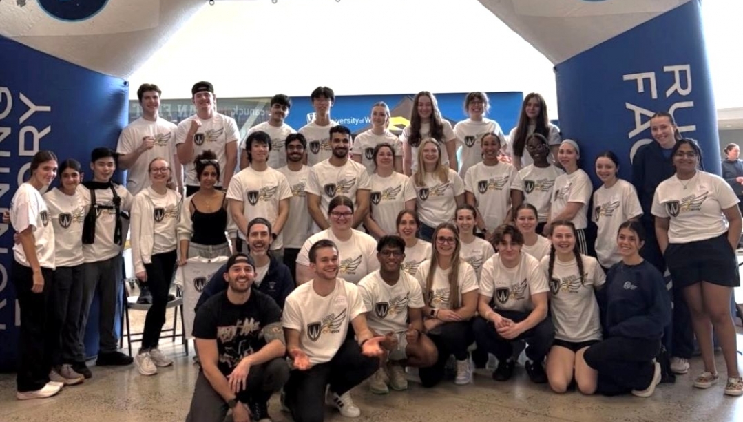 Group of students in front of inflatable running factory banner