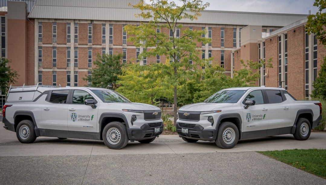 Two electric pick-up trucks parked on UWindsor campus