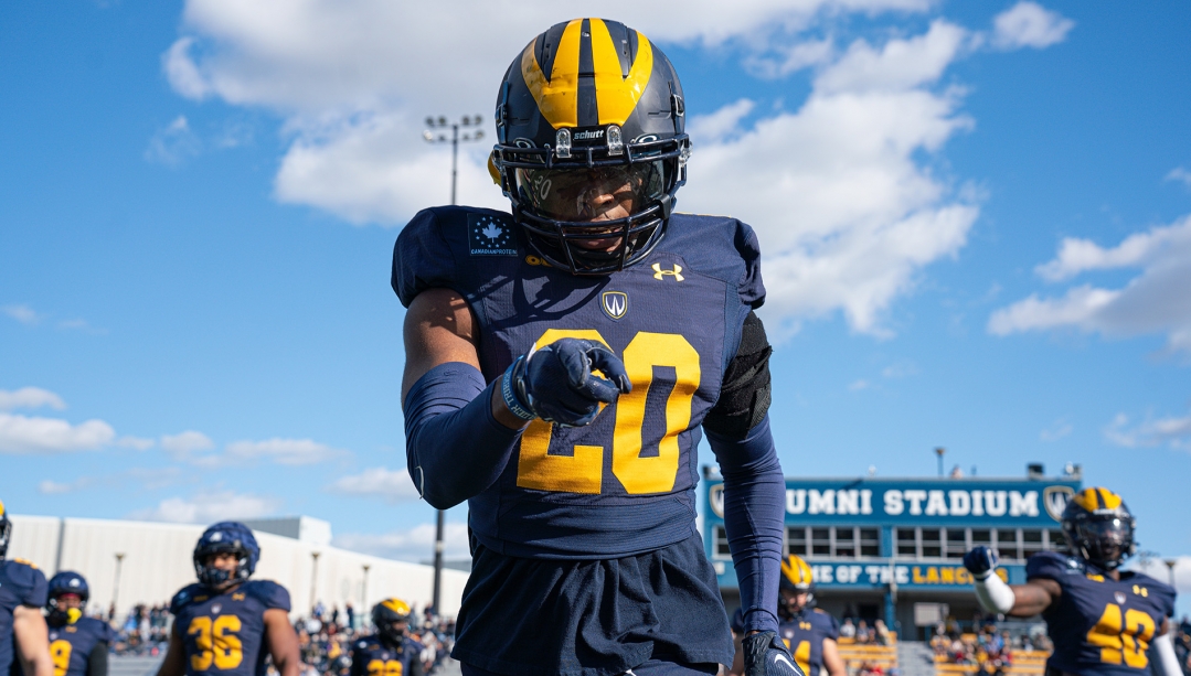 Windsor Lancers football player poses for photo by pointing at camera.