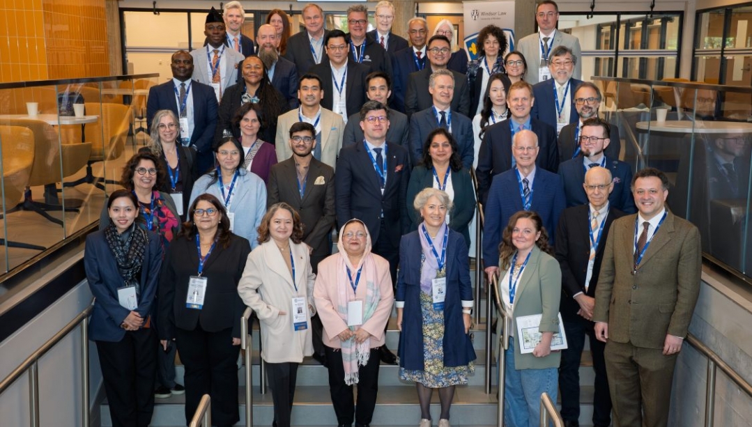 Deans from around the world stand together in the Ianni law building at UWindsor
