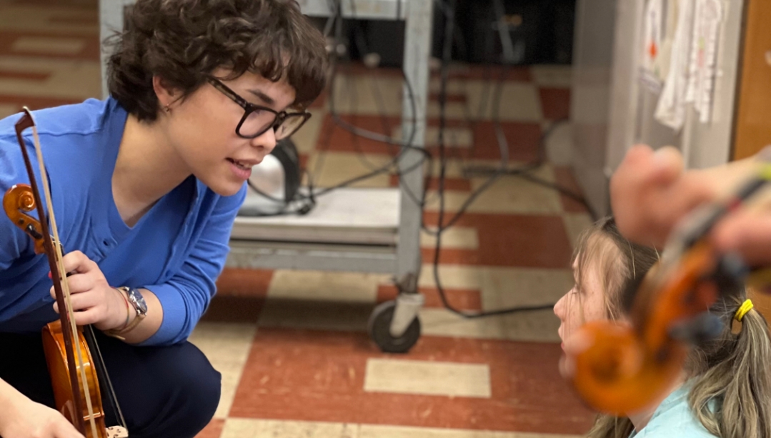 Avery Ng instructing with a violin