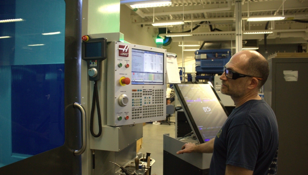Technician using 3D printing machine at UWindsor